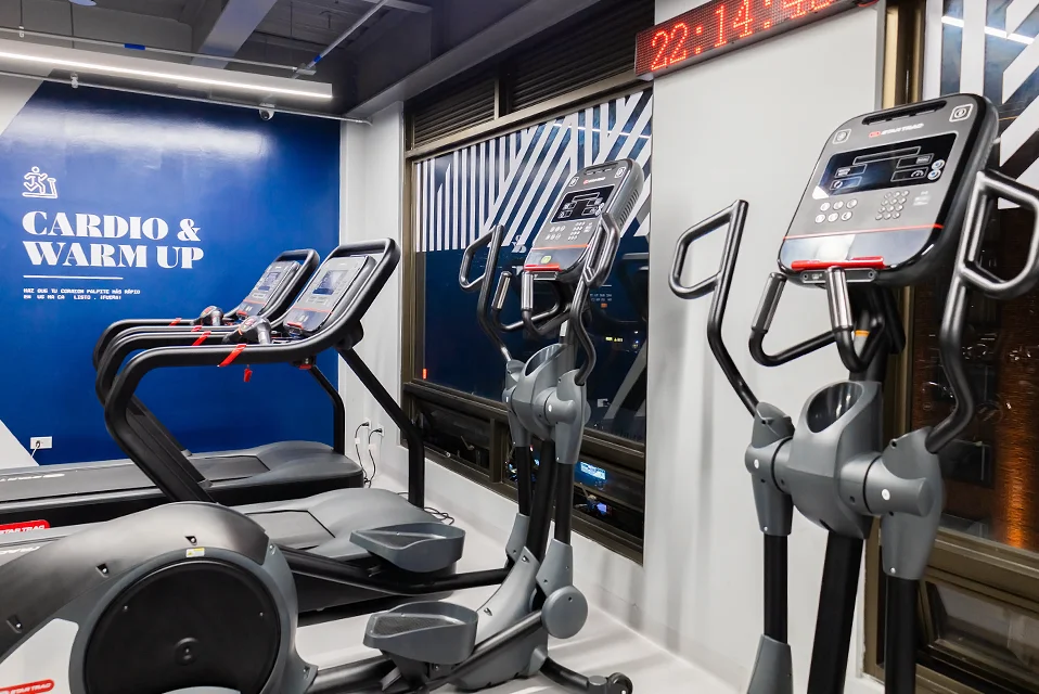 Área de cardio equipada con caminadoras y máquinas para entrenamiento cardiovascular.